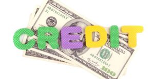 Foam letters spelling Credit laying over a stack of $100 bills earned from the child tax credit.