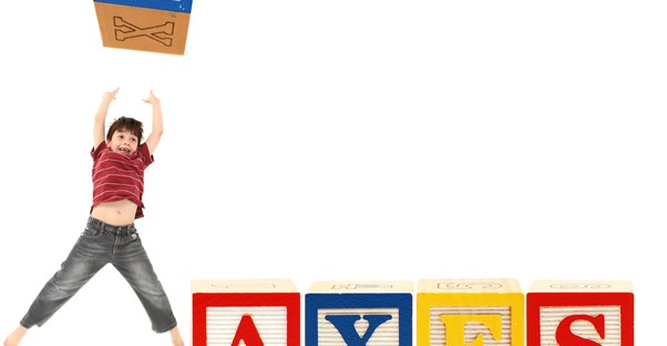 A young boy throws a block with the t from Taxes in the air when he learns the child tax credit saves his parents money.