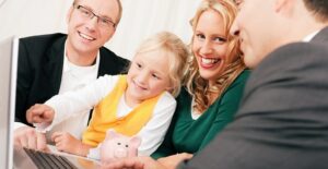 A family of three smiles as they fill out the child tax credit paperwork with their financial adviser because they qualify.
