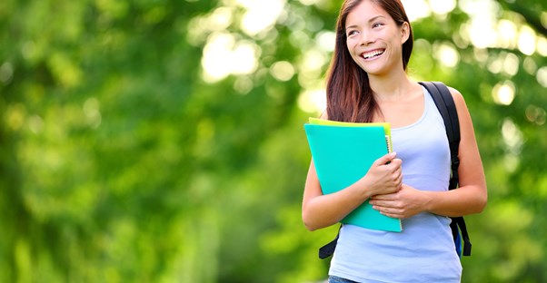 A college student smiles as she walks to class because she has enough financial aid to get her through school.