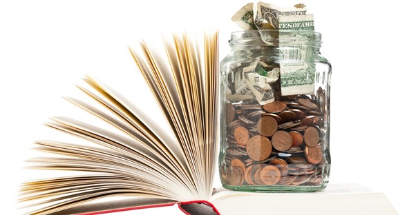 A jar of change sitting on top of a Pell Grant rule book.