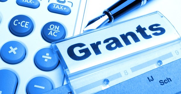 A calculator and GRANT label laying on a desk as a student applies for the Pell Grant.