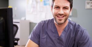 A new nurse practitioner smiles because he has finished his training and is now licensed.