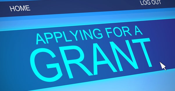 A computer screen reading APPLYING FOR A GRANT as a college student researches Pell Grant qualifications.