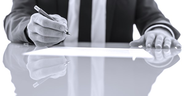 A man pauses to this of the disadvantages of having a financial adviser before he signs an agreement.