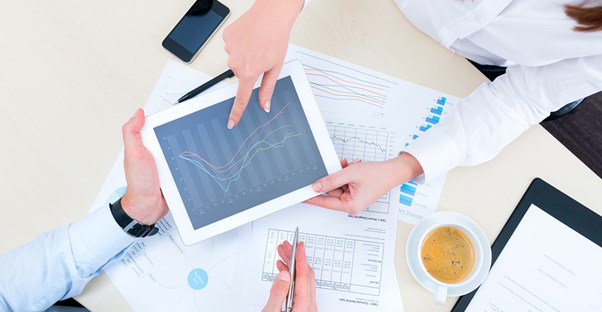 A woman looking over graphs and asking her financial adviser questions.