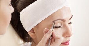 a woman has her eyebrows shaped and trimmed