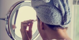 a woman grooms her eyebrows at home