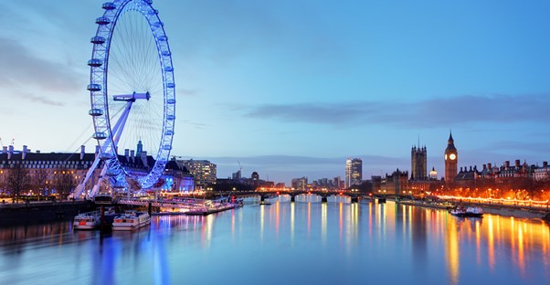 the London Eye sits in the foreground on the banks of the Thames
