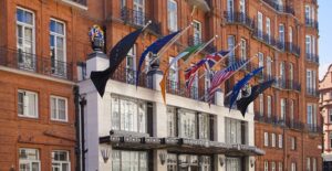 the ritz hotel with international flags displayed over the entrance
