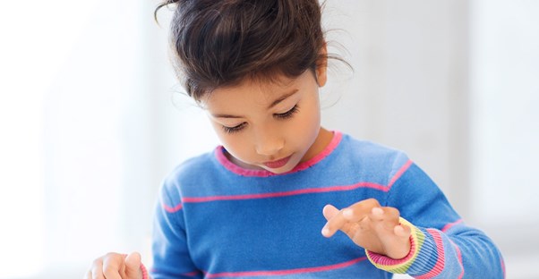 a young girl plays with apps on her tablet