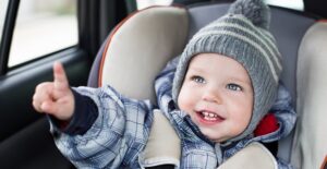 a toddler enjoys riding in his car seat