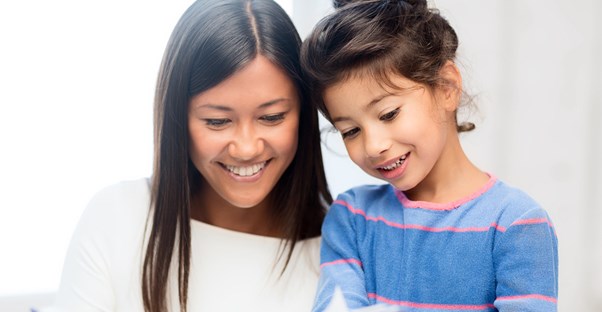 a young adopted girl and her mother read a book together