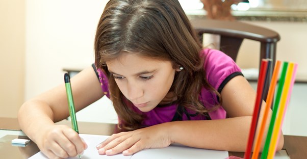 a young girl writes in a book