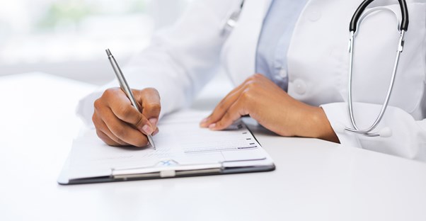 a doctor writes out the symptoms of a blood clot onto a medical pad