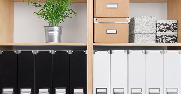 organized shelves are filled with labled binders and boxes