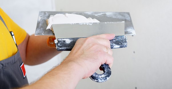 A homeowner prepares to lay tile for his bathroom remodel.