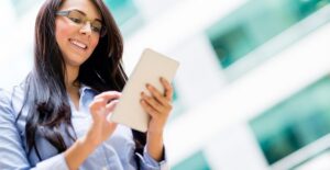 Young woman smiles as she takes her handy tablet with her to work and school.