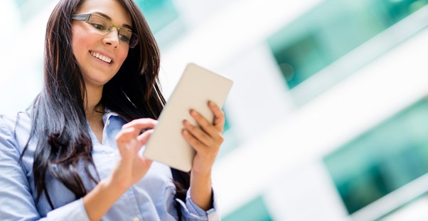 Young woman smiles as she takes her handy tablet with her to work and school.