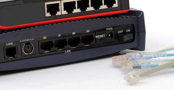 A bundle of Ethernet cords laying next to the back of a modem.
