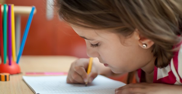 A young girl pretends to do homework