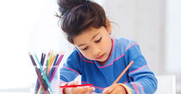 Young girl doodles with colored pencils