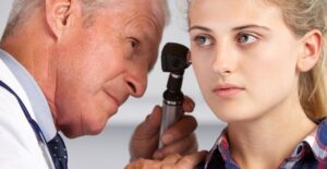 A creepy old man stares into the ear of a young woman