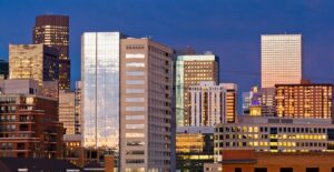 the setting sun reflects off the skyscrapers of downtown denver