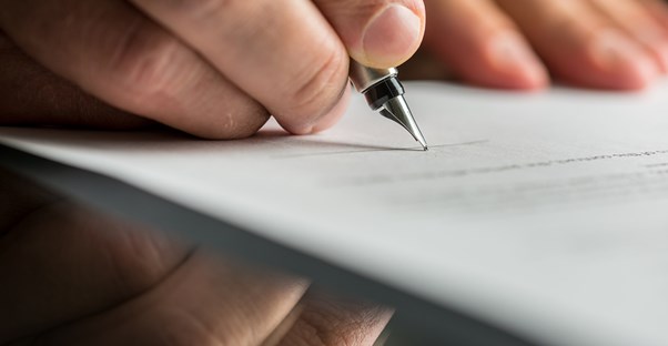 Hand Holding A Pen and Writing