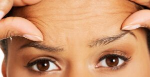 A frustrated woman examines her skin as she tries to figure out what skincare mistakes she is making