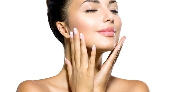 A twenty something woman smiles knowing her skin will age well because she takes good care of it.