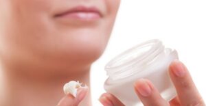A woman with sensitive skin uses a gentle moisturizer on her face.