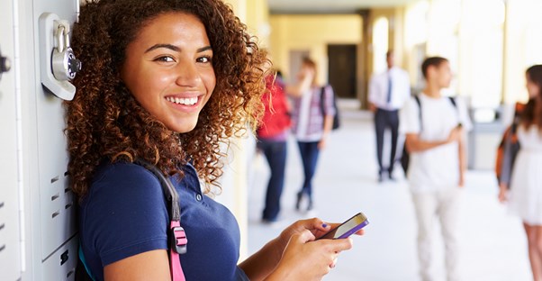Teenage girl smiling because her phone is protected by accessories