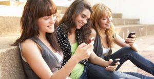 Teens using cell phones in school to study.