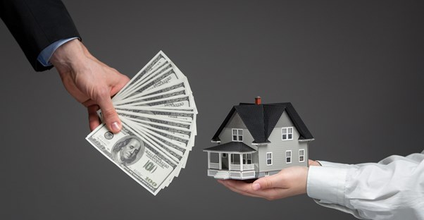 Hand holding money and hand holding a tiny house