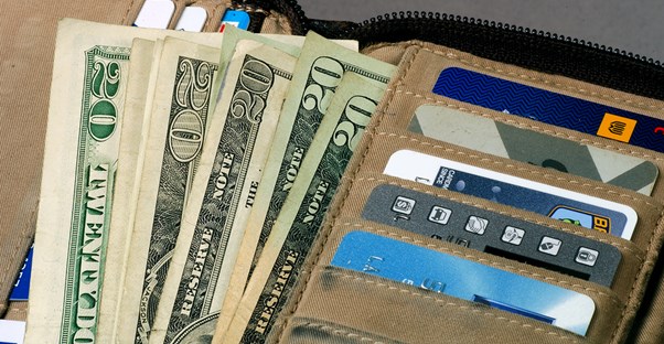 a travel wallet overflows with cash and credit cards