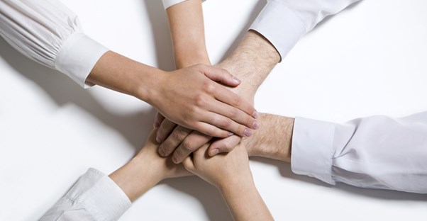 Human resource managers pile their hands on one another and yell BREAK!