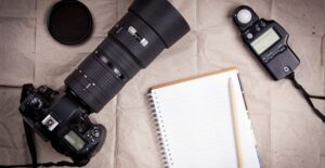 camera lenses and other gaer lie on a bed ready to be packed