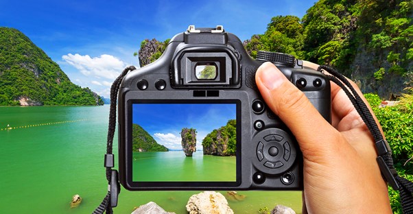 a photographer centers a picture with the viewfinder