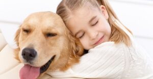 a young girl hugs her family dog