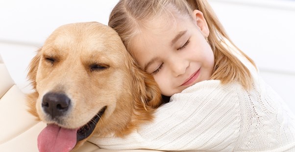 a young girl hugs her family dog