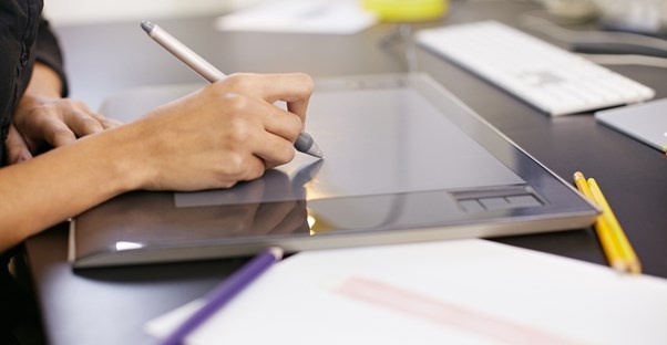 Fashion designer draws sketches on a tablet