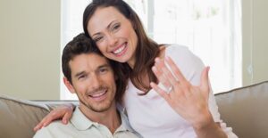 Couple smiles after he proposes with a custom engagement ring