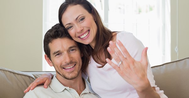 Couple smiles after he proposes with a custom engagement ring