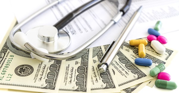 Pills, stethoscope, and dollar bills