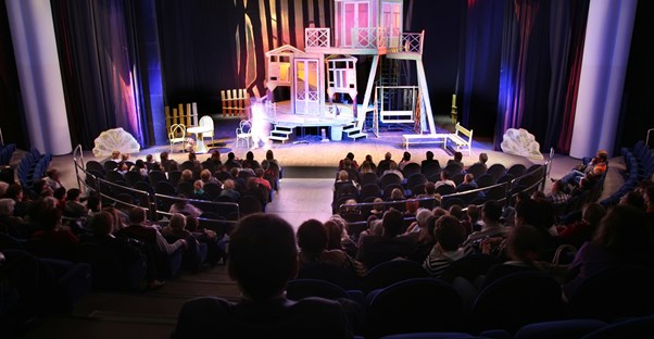 the curtain opens on a broadway set