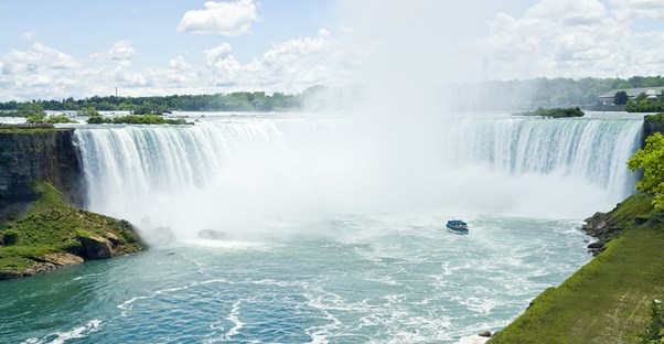 a boat sails in for a close up view of niagara falls