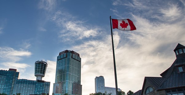 a canadian flag flies above the canada side of niagara falls