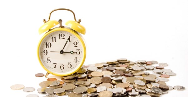 Alarm clock in a pile of coins