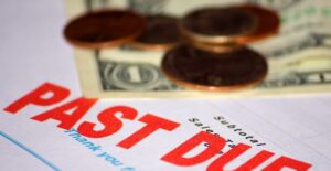 Past due bill with pennies and dollar bills